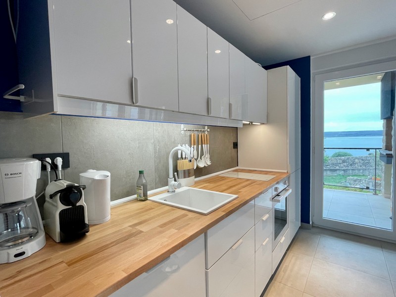 Bočný pohľad na moderné žlté obytné budovy s balkónmi a kamennými detailmi na predaj v Zadare, Chorvátsko