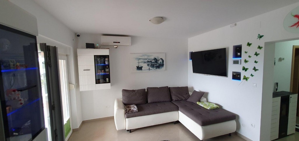 Útulná, zariadená obývacia izba s pohovkou a klimatizáciou.