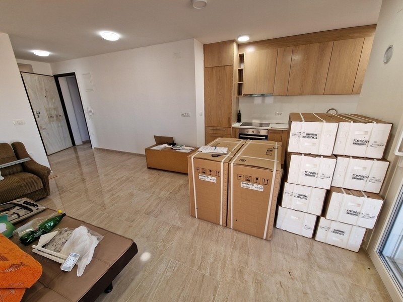 Moderný obývací priestor s otvoreným konceptom a kuchyňou.