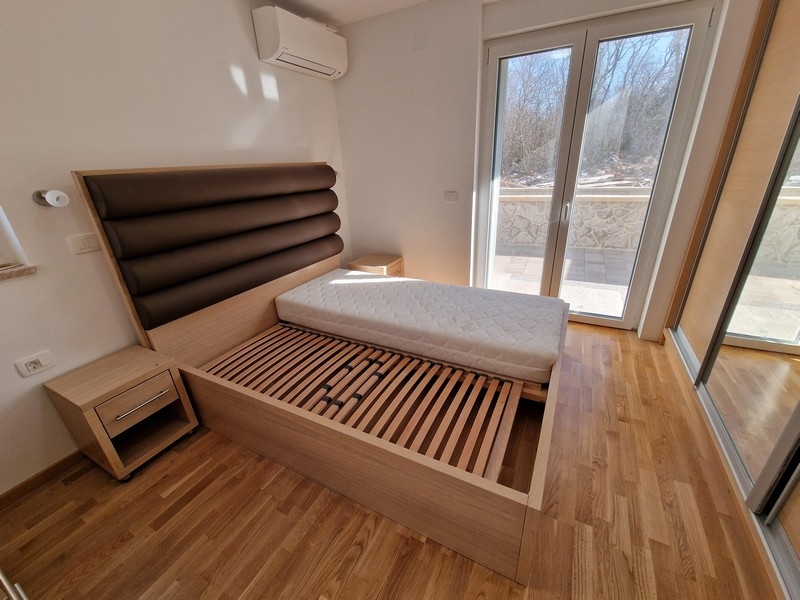 Manželská posteľ v spálni a výhľad na terasu.