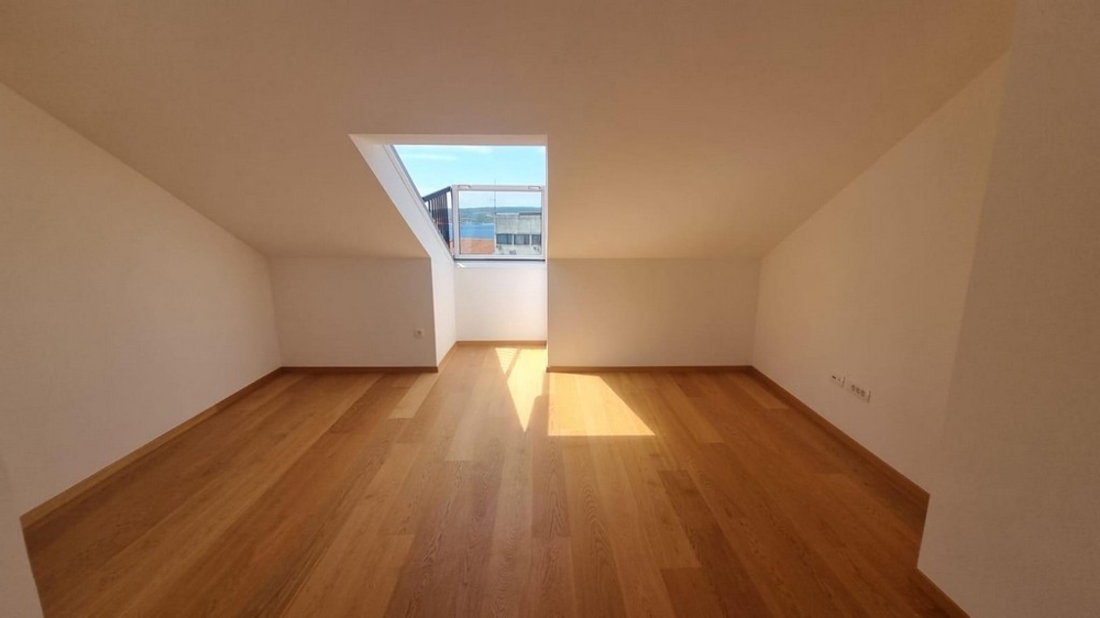 Svetlá spálňa so strešným oknom.