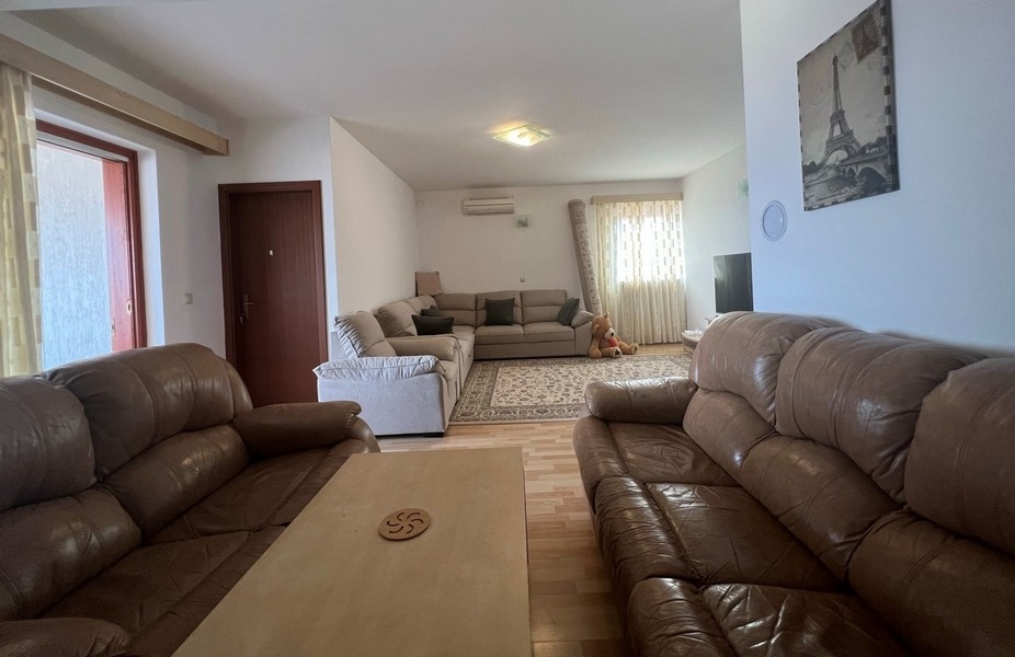 Obývacia izba s tromi pohovkami.