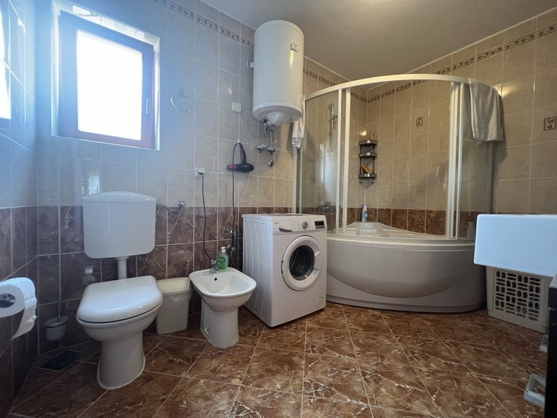 Veľká kúpeľňa so sprchovacím kútom a práčkou.