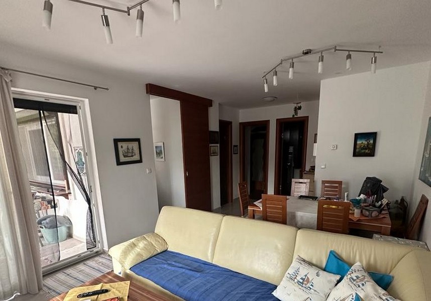 Zariadený obývací priestor a výhľad na jedálenský stôl.