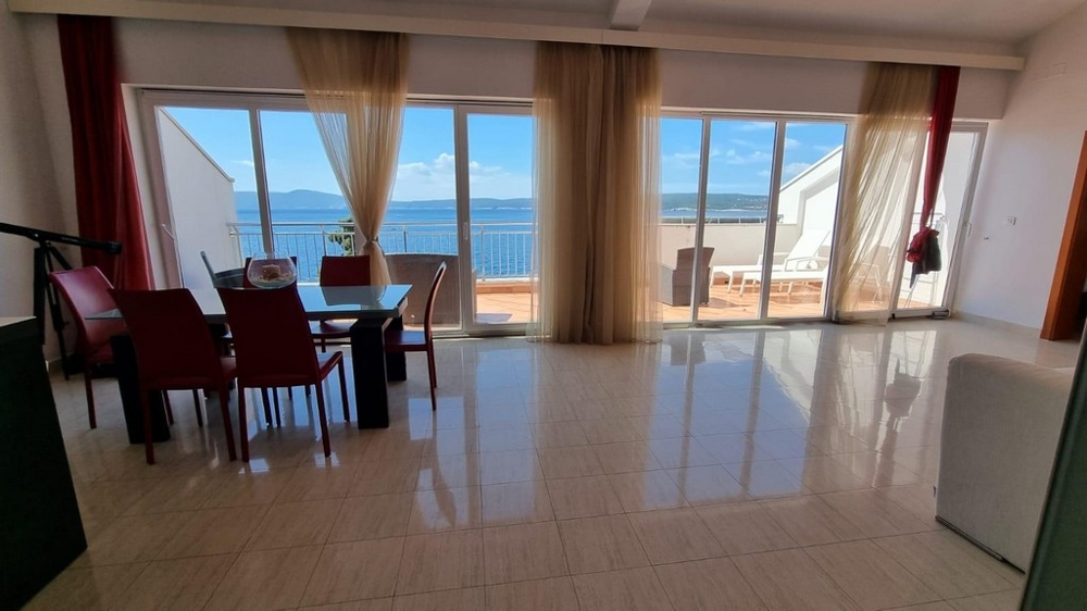 Obývacia izba s výhľadom na terasu a more.