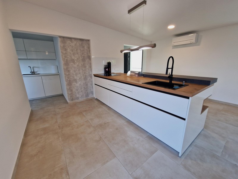 Kuchynský ostrovček a výhľad na klimatizáciu nehnuteľnosti A3043 v Chorvátsku.