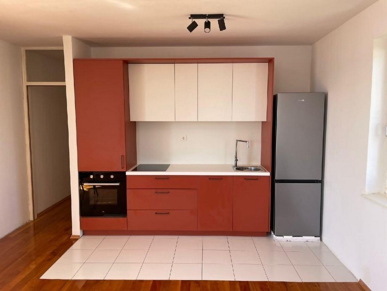 Moderná kuchyňa s červenými prvkami v nehnuteľnosti A3137, ktorá sa predáva v Chorvátsku.