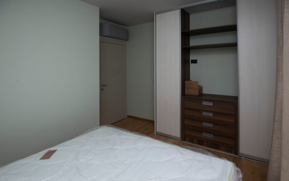 priestranná spálňa moderného bytu v Splite v Chorvátsku na predaj so vstavanou skriňou a drevenou podlahou.