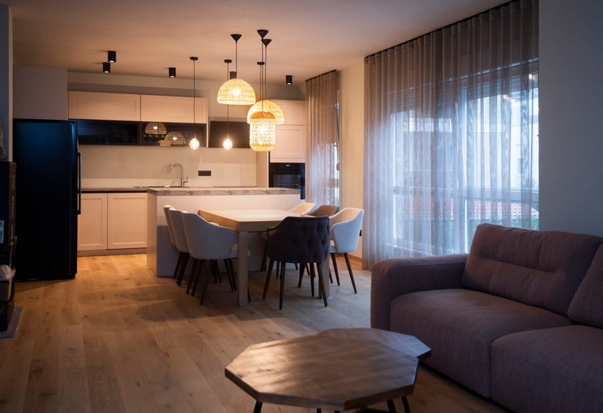 Moderná kuchyňa a jedálenský kút v byte na predaj v chorvátskom Splite so štýlovým osvetlením a otvoreným pôdorysom.