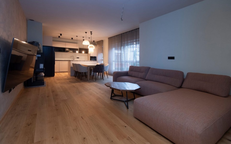 Priestranná a svetlá obývacia izba v modernom apartmáne v Splite v Chorvátsku s parketovými podlahami a elegantným nábytkom.