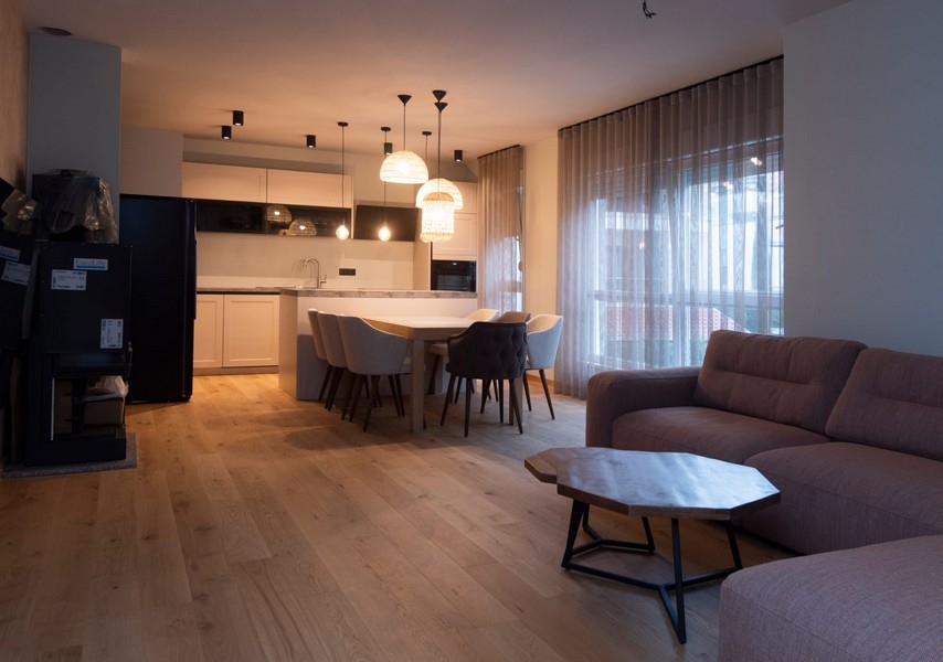 Elegantná a moderná obývačka s priechodom do kuchyne v apartmáne v Splite v Chorvátsku, ideálna na zábavu.