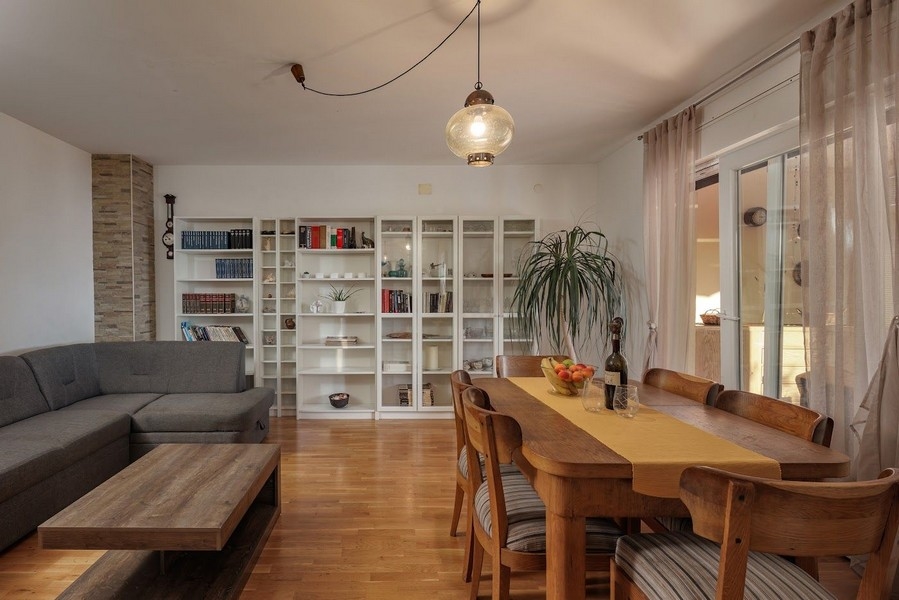 Obývací a jedálenský kút s policou a veľkým stolom v chorvátskom majetku.