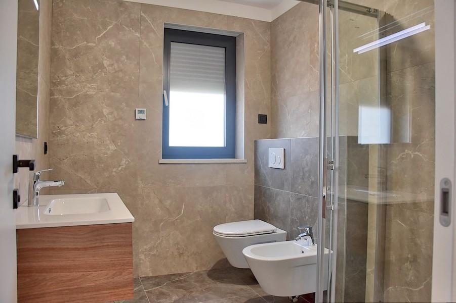 Elegantná kúpeľňa v strešnom byte na predaj na Istrii s moderným vybavením a mramorovými obkladmi.