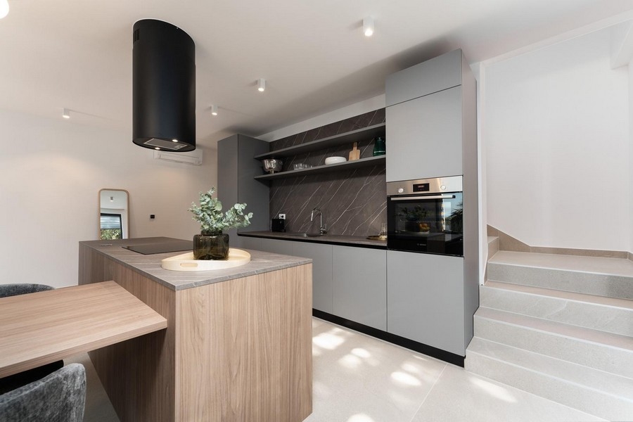 Moderná kuchyňa s centrálnym varným ostrovčekom a kvalitnými vstavanými spotrebičmi v luxusnom apartmáne na Istrii