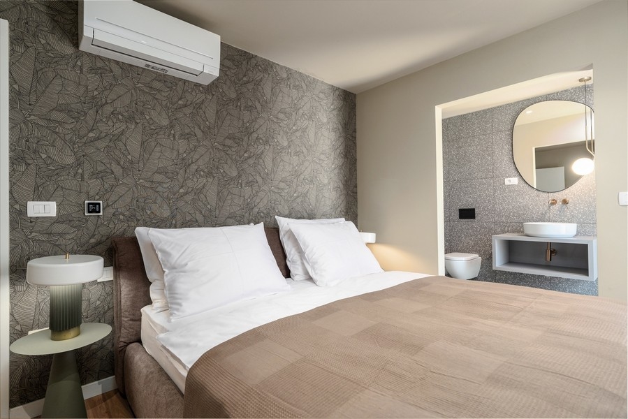Spálňa v luxusnom apartmáne na Istrii s dizajnovou stenou a moderným interiérom