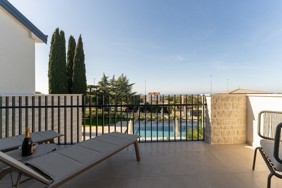 Výhľad z terasy na bazén a more v luxusnej nehnuteľnosti na Istrii