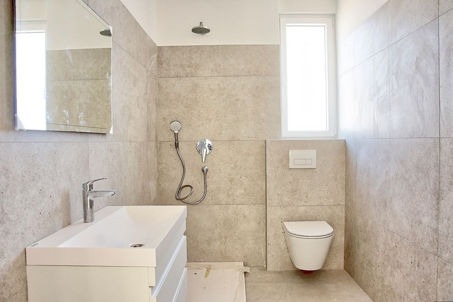 Štýlová kúpeľňa s moderným vybavením a jemným kamenným obkladom v luxusnom apartmáne na Istrii