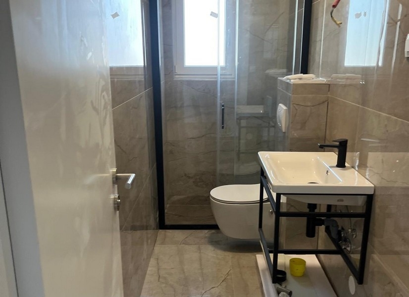 Kúpeľňa s moderným sprchovacím kútom a umývadlom