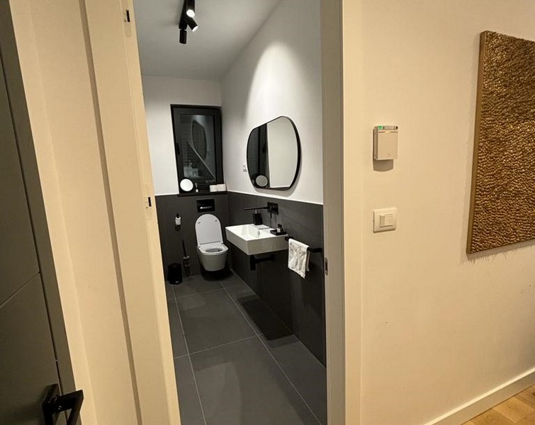 Moderná kúpeľňa so sivými obkladmi a zrkadlami, nehnuteľnosť na predaj v Rijeke, Chorvátsko.