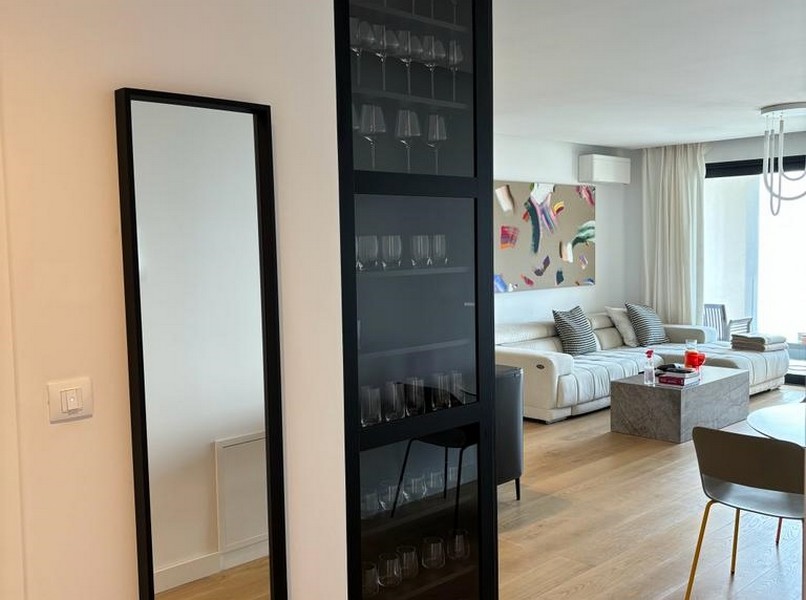 Elegantný stojan na víno vedľa čiernych sklenených dverí, detail bytu na predaj v Rijeke, Chorvátsko.