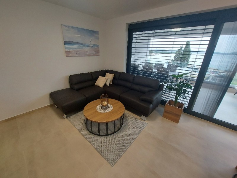 Obývacia izba s gaučom a príručným stolíkom v strešnom apartmáne na predaj v Zadare, Chorvátsko, s prístupom na terasu
