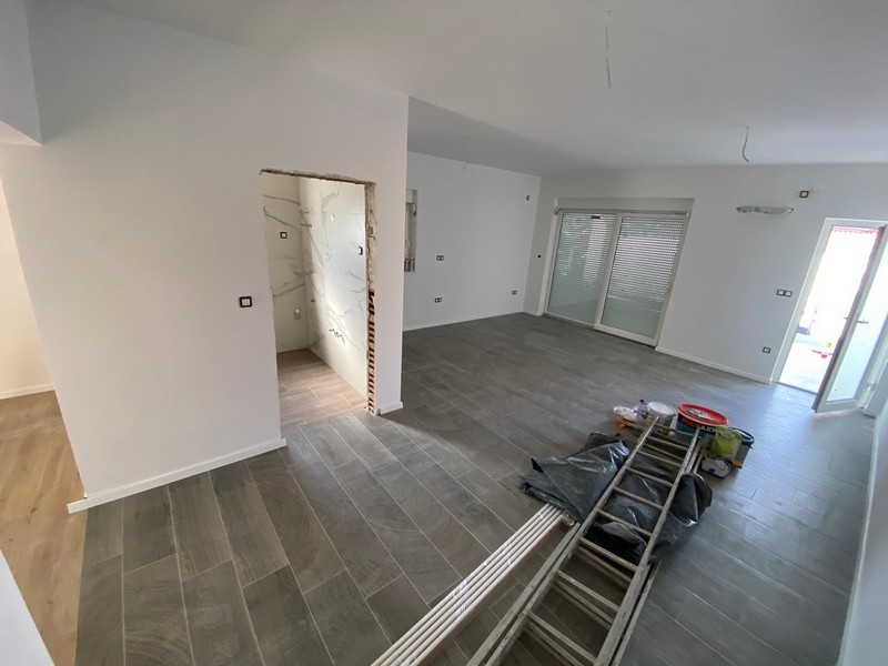 Prázdny obývací priestor so sivou dlažbou v byte na predaj v Pagu, Chorvátsko