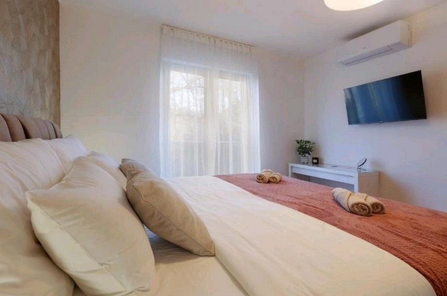 Spálňa s veľkou posteľou a TV v byte, na predaj neďaleko Opatije, Chorvátsko