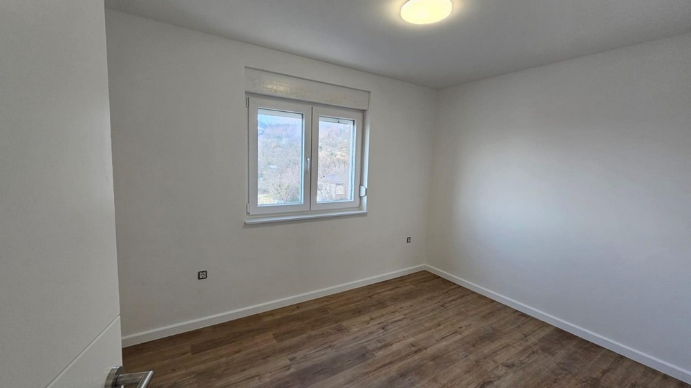 Prázdna spálňa v byte na predaj v Crikvenici, Kvarnerský záliv, s drevenými podlahami a bielymi stenami