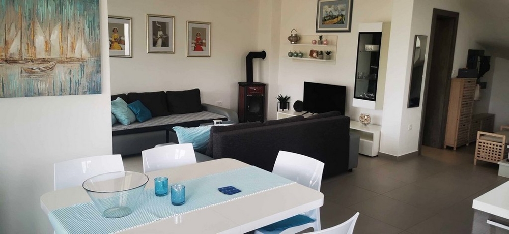 Priestranná otvorená obývacia izba a jedáleň v apartmáne v Tisno, Chorvátsko na predaj s moderným zariadením.