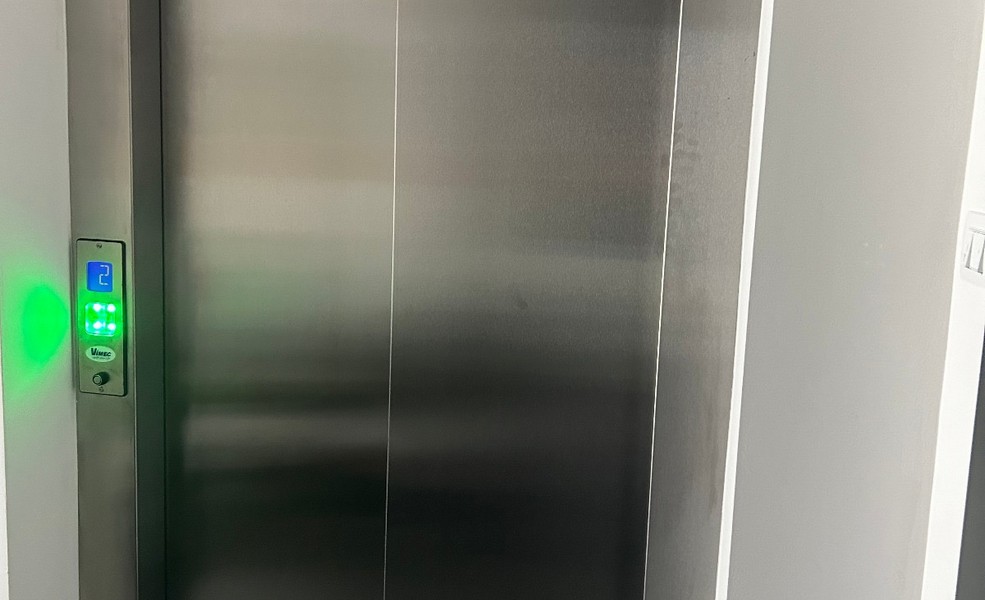 Interiérový záber na moderný výťah s nerezovými dverami v bytovom dome v Rijeke.