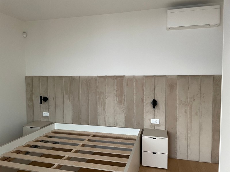 Minimalistická spálňa so vstavanou posteľou a klimatizáciou v apartmáne v Rijeke.