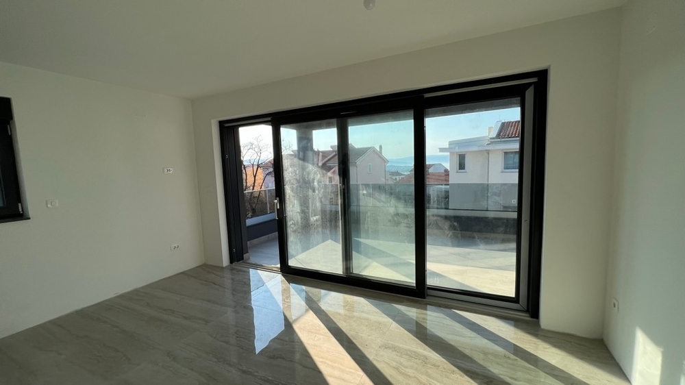 Svetlý obývací priestor s oknami od podlahy až po strop zapadá do moderného konceptu nehnuteľnosti na ostrove Krk.