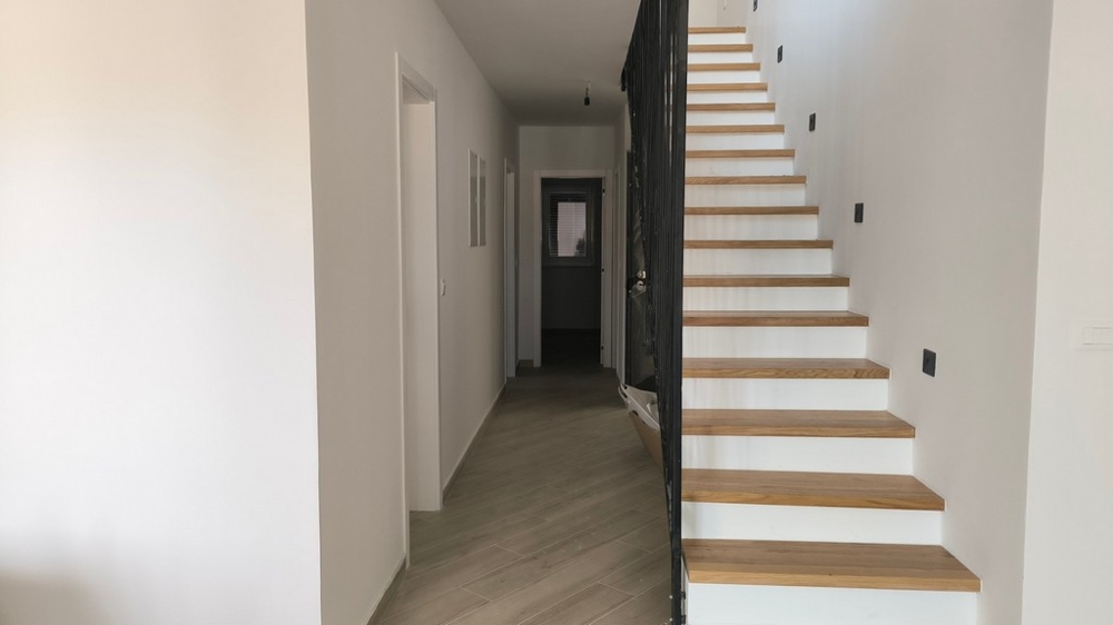 Predsieň moderného strešného bytu v Chorvátsku v Šimuni so schodmi vedúcimi na horné poschodia.