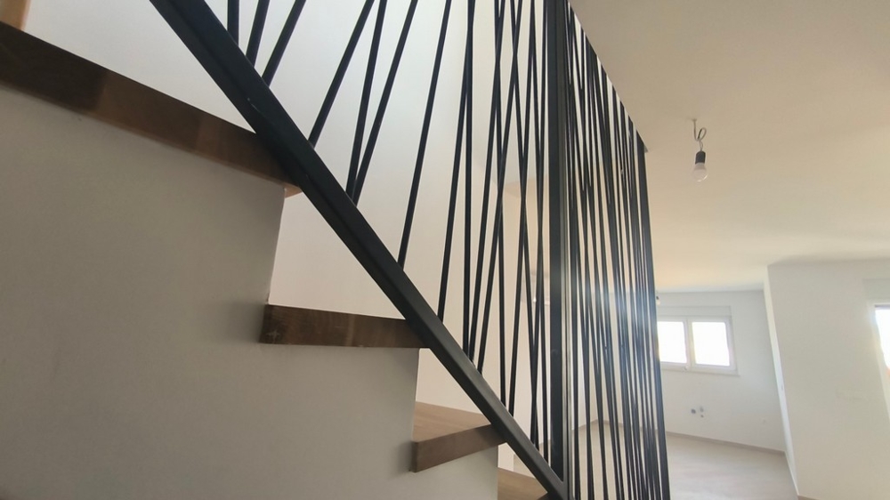 Vnútorné schodisko s moderným zábradlím v penthouse, chorvátska nehnuteľnosť v Šimuni, ktoré spája eleganciu a dizajn.