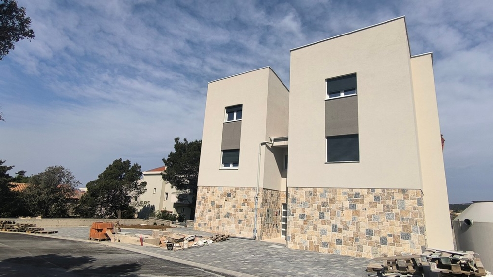 Vonkajší pohľad na dve novopostavené budovy, nehnuteľnosť v Chorvátsku v Šimuni s viditeľným vstupným priestorom.