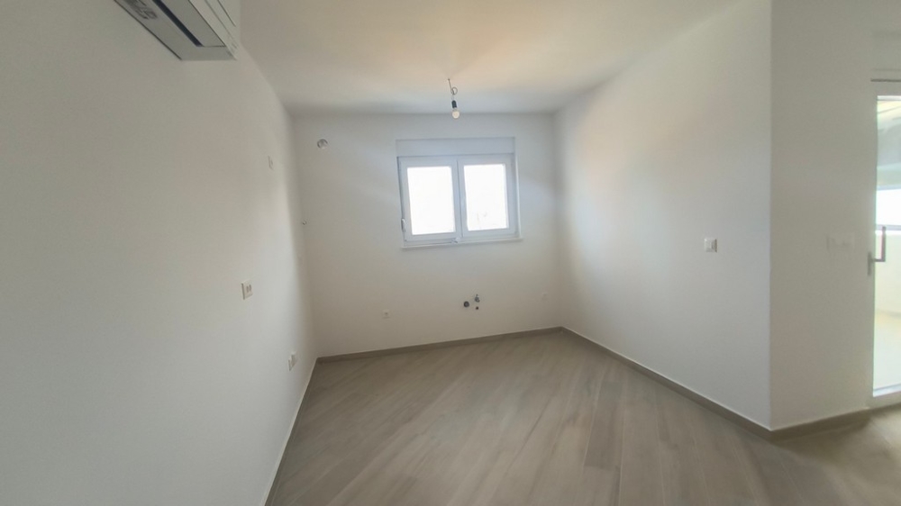 Priestranná, prázdna spálňa v podkrovnom apartmáne v Chorvátsku s výhľadom na okolie Šimuni.