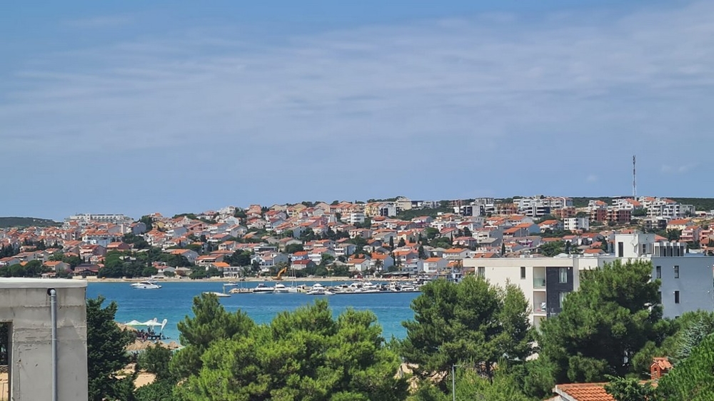 Panoramatický výhľad na Novalju, ostrov Pag, s výhľadom na apartmány a pobrežie modrého mora, chorvátska nehnuteľnosť