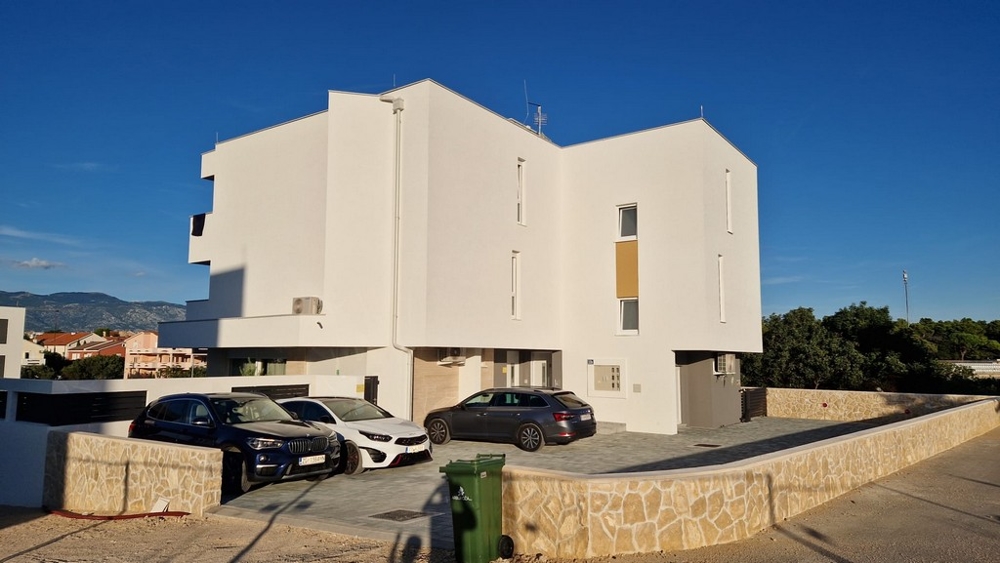 Bočný pohľad na moderný bytový dom s parkovacími miestami v Novalji, ostrov Pag, Chorvátsko