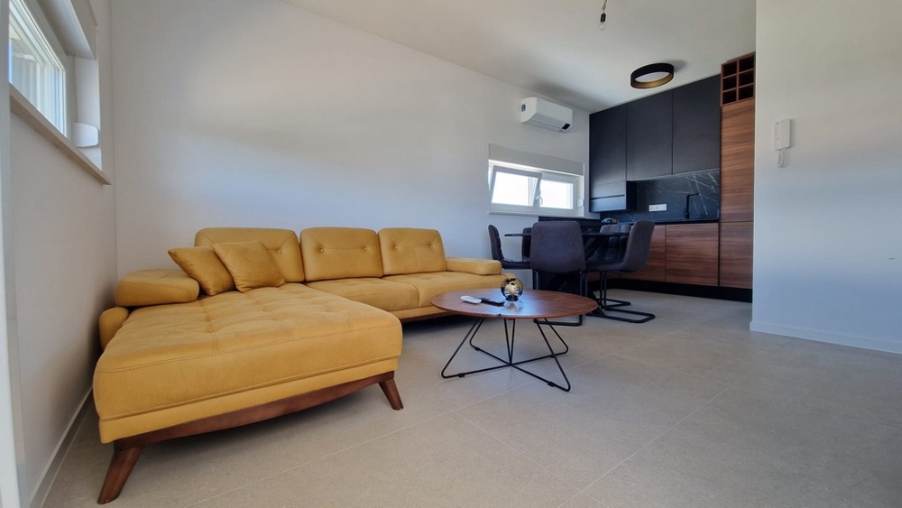 Interiér bytu v Novalji, ostrov Pag, s moderným zariadením a žltou pohovkou, chorvátska nehnuteľnosť