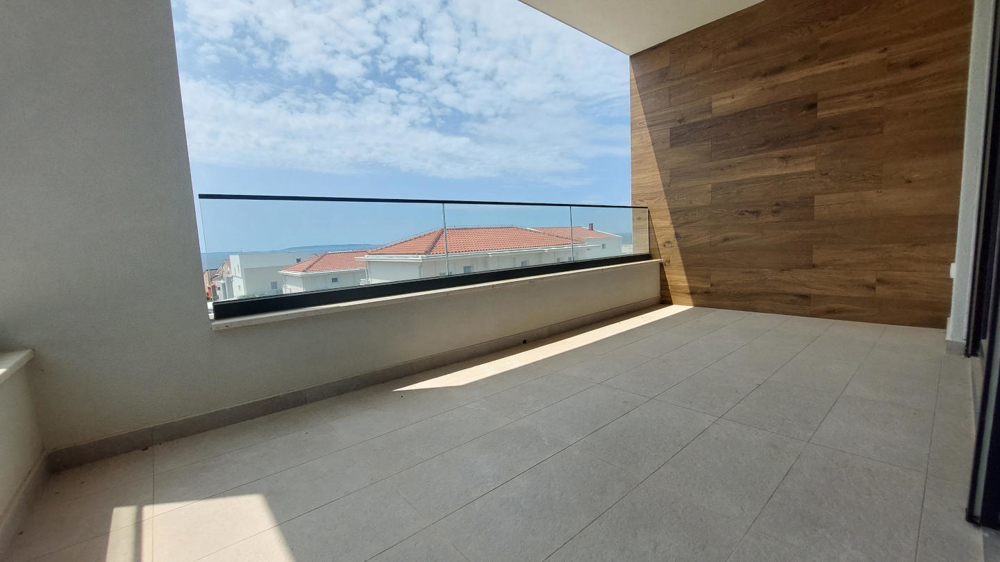Moderná vila s prázdnym bazénom v popredí, dreveným obložením a priestrannými balkónmi