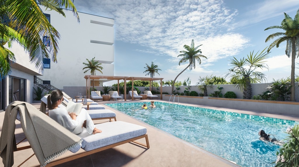 Nehnuteľnosti v Chorvátsku, Makarska, apartmán s výhľadom na more: Žena číta knihu na ležadle pri bazéne, obklopená palmami a pozerá na more