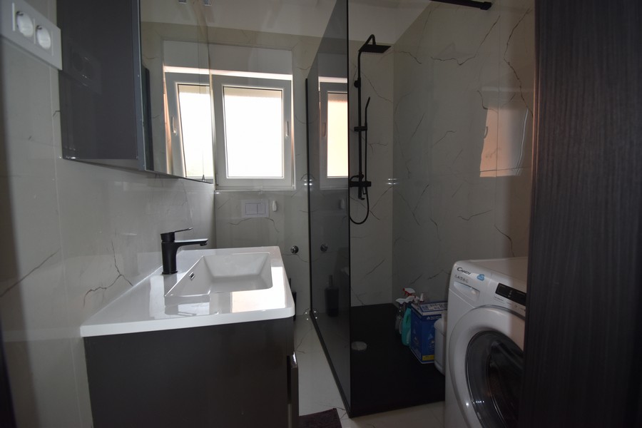 Moderná kúpeľňa so sprchovacím kútom a práčkou, súčasť Real Estate Croatia