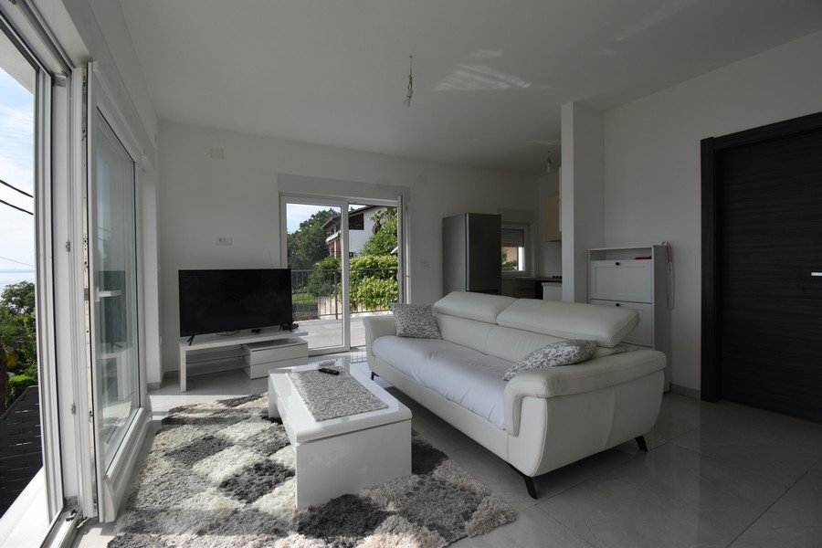 Svetlá obývacia izba s veľkými oknami a výhľadom na more, chorvátska nehnuteľnosť