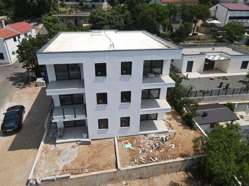 Pohľad na moderné novopostavené apartmány v Chorvátsku obklopené zeleňou