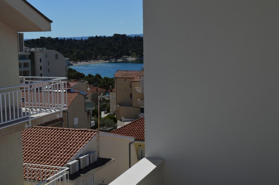 Čiastočne zakrytý výhľad na more z balkóna nedokončeného bytu.