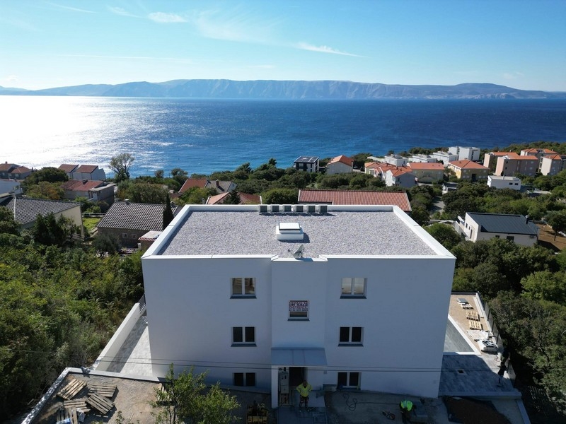 Pohľad spredu na bytový dom s balkónmi a bazénom v Smokvici Krmpotskej