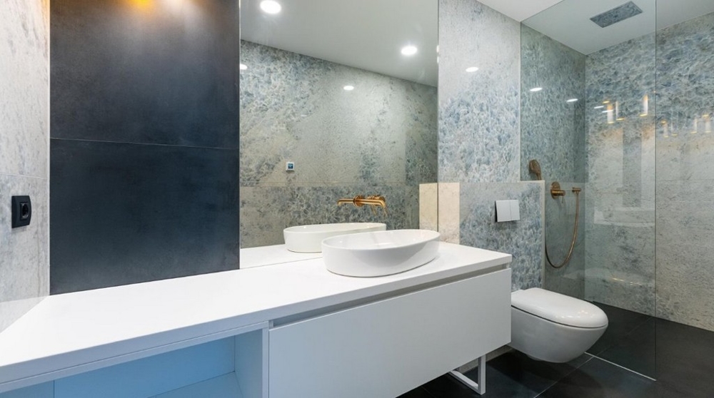 Moderná kúpeľňa s bielym umývadlom, presklenou sprchou