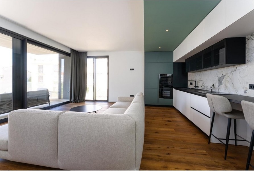 Obývacia izba s rohovou sedačkou, veľké okná, vstup na balkón