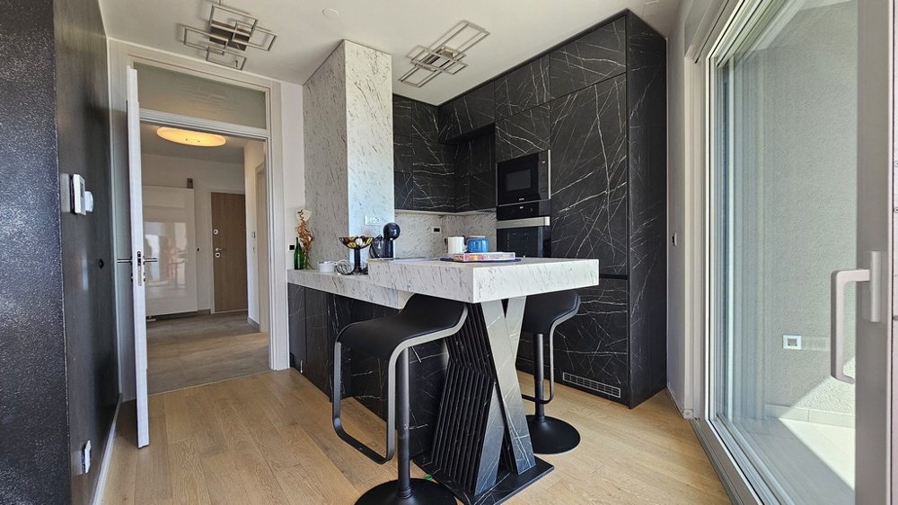 Moderná kuchyňa s čiernym dizajnom a barovými stoličkami