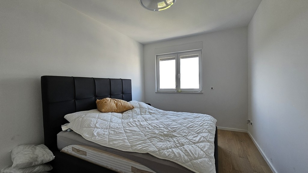 Spálňa s veľkou posteľou a bielou perinou